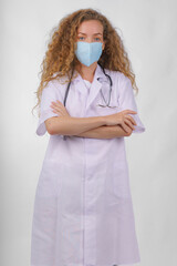 caucasian female doctor in lab coat with stethoscope and wearing face mask