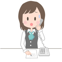 困った表情で電話応対をする事務員の女性
