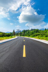 Asphalt road and green mountain natural scenery in Hangzhou on a sunny day.