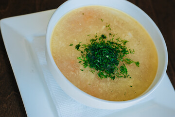 Diet chicken soup. Lean broth. Nutrition for gastritis and coronavirus. Healthy food. White cup on dark background