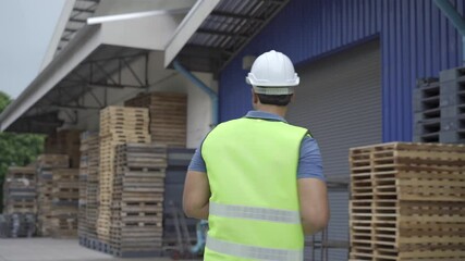 20s happy Indian distribution shipping depot worker looking at camera and smile. Logistics worker wearing a hard helmet dancing and having fun at shipment center - 4K Real Time Footage