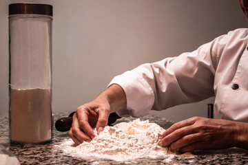 Obraz na płótnie Canvas Unrecognizable woman cooking with flour