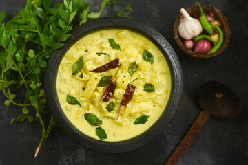 Bowl of homemade  Ash gourd yellow curry spices, buttermilk sour cream curd yogurt Dahi fresh herbs curry leaf Kerala, India. Dairy product coagulating milk , curdling. probiotic food. tasty curd rice