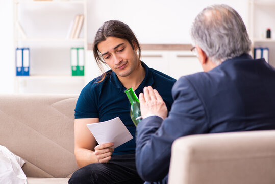 Alcohol addicted young man visiting old male psychologist - Powered by Adobe