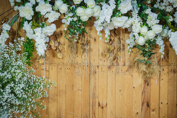 Floral background. Lot of artificial flowers on wooden wall.