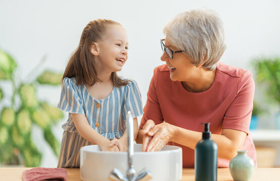 girl and her grandmother are washing hands