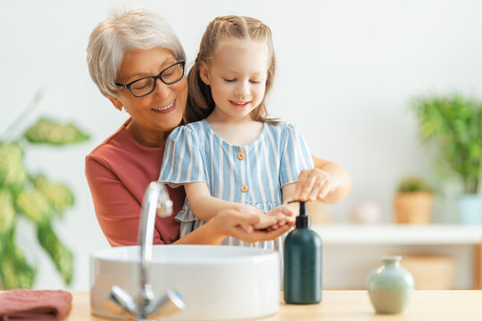girl and her grandmother are washing hands
