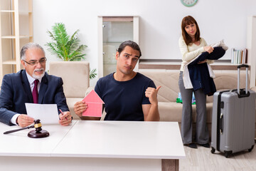 Old experienced judge and young couple in divorcing concept