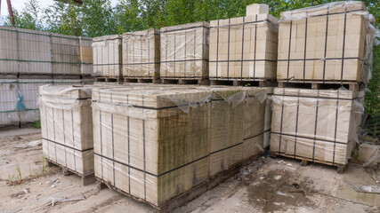 Packed with bandage tapes and stretch film bricks are stacked on wooden pallets in an abandoned warehouse