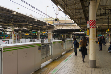 people standing on the platform of train station in Tokyo, Japan 