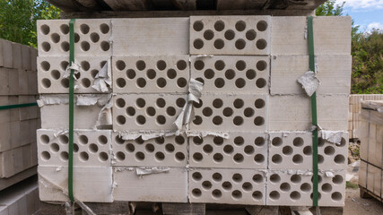 Packed with bandage tapes and stretch film stack of bricks are stacked on wooden pallets in an abandoned warehouse