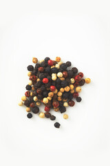 A handful of different types of pepper isolated on a white background. 