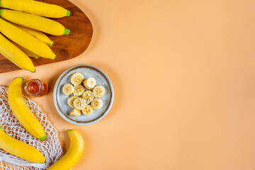 Top view of sliced banana and honey with copy space, Healthy food on pastel orange background