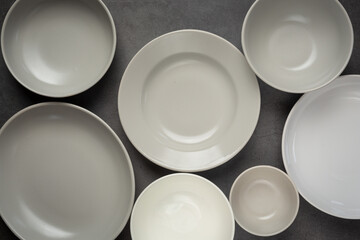Obraz na płótnie Canvas white round empty plates and bowls on dark background