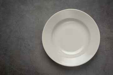 a white round empty  plate on dark background