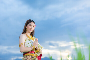 beautiful woman in thai traditional outfit smiling and standing at temple