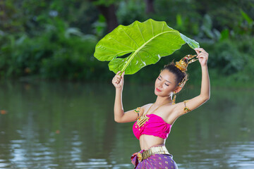 Loy Krathong Festival;woman in thai traditional outfit holding banana leaf
