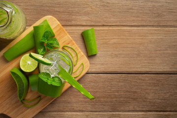 a glass of aloe vera  juice put on wooden cutting board