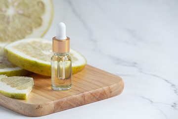 grapefruit oil serum bottle put on white marble background