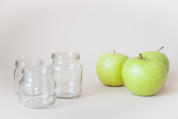 Green ripe apples and empty transparent jars for baby food
