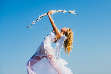 Angel teen with feather white wings. Cupid shoots a bow.