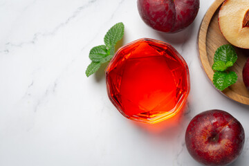 a glass of plum put on white marble floor