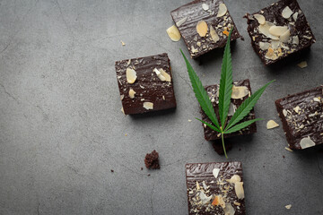 cannabis brownies and cannabis leaves put on dark floor