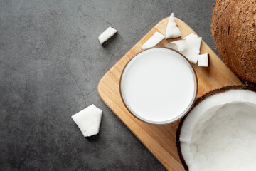 a glass of coconut milk put on wooden cutting board