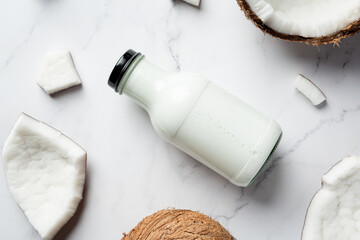 the bottle of coconut milk put on white marble background