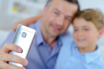 Close up of cell being used to photograph father and son