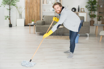 happy man with mop cleaning floor
