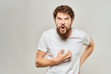man in white t-shirt emotions expressions gesture with hands cropped view light background