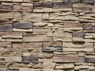 Muro con recubrimiento decorativo cafe-gris iluminado a la luz del medio día 