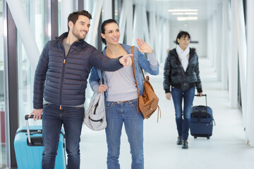 man and woman in airport pointing and waving