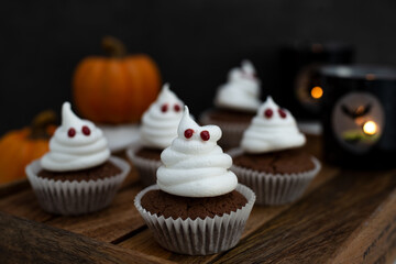 Halloween ghost cupcakes , homemade sweet chocolate muffins with meringue ghost