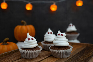 Halloween ghost cupcakes , homemade sweet chocolate muffins with meringue ghost