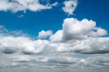 Blue clear sky with white fluffy clouds. Natural background