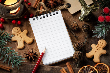 Christmas planning concept - festive setting with a notepad, a pencil and festive seasonal decorations with plenty of copy space for your text