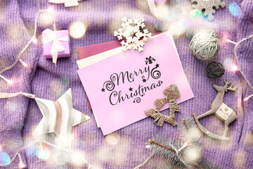 Christmas composition with greeting cards and decor on warm sweater