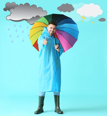 Young man in raincoat holding umbrella on color background with drawn clouds