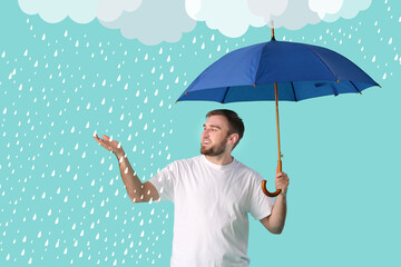 Handsome young man holding umbrella on background with drawn rain