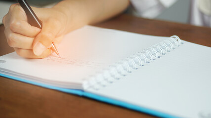 a woman holding a pen and writing.
