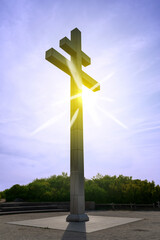 The Cross of Lorraine monument at Juno Beach in Normandy, France stands tall in front of the sun,...