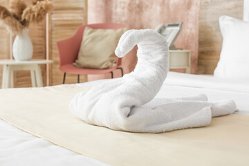 Fototapeta na wymiar Swan made of towel on bed in hotel room