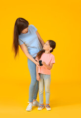 Mother and her diabetic daughter with glucometer on color background