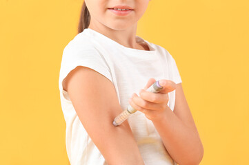 Little diabetic girl giving herself insulin injection on color background