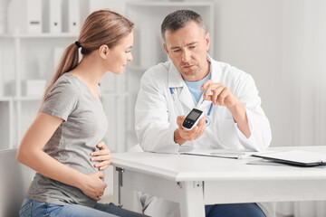 Fototapeta premium Pregnant diabetic woman visiting doctor in clinic