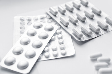white sprinkled vitamins from a jar on a white table