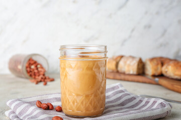 Jar of tasty peanut butter on table