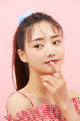 Fototapeta premium かわいい女の子のカジュアルなビューティーポートレート ( ピンク背景 )